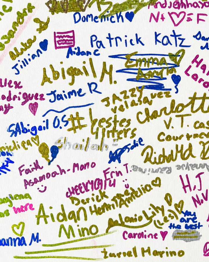 A cast poster covered in colorful student signatures and hearts from a Kawameeh Middle School musical